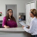 Office staff person answering patients questions
